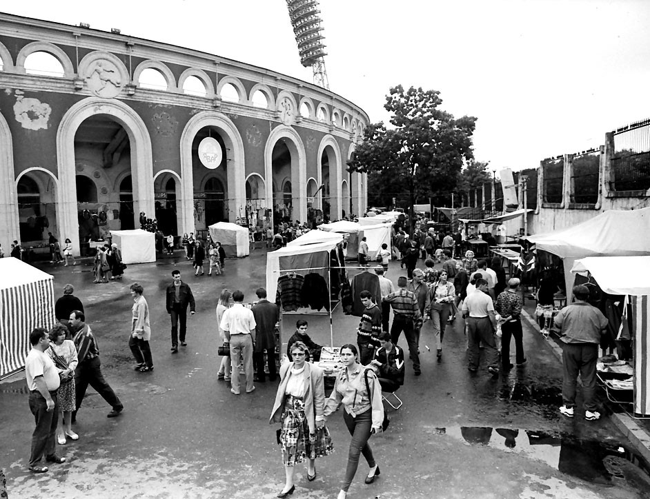 Market at the Dynamo Stadium, early 1990s. In a situation where the old state trade system was collapsing, many people found the goods they needed at these markets. These goods were brought in by small traders - "shuttle traders"